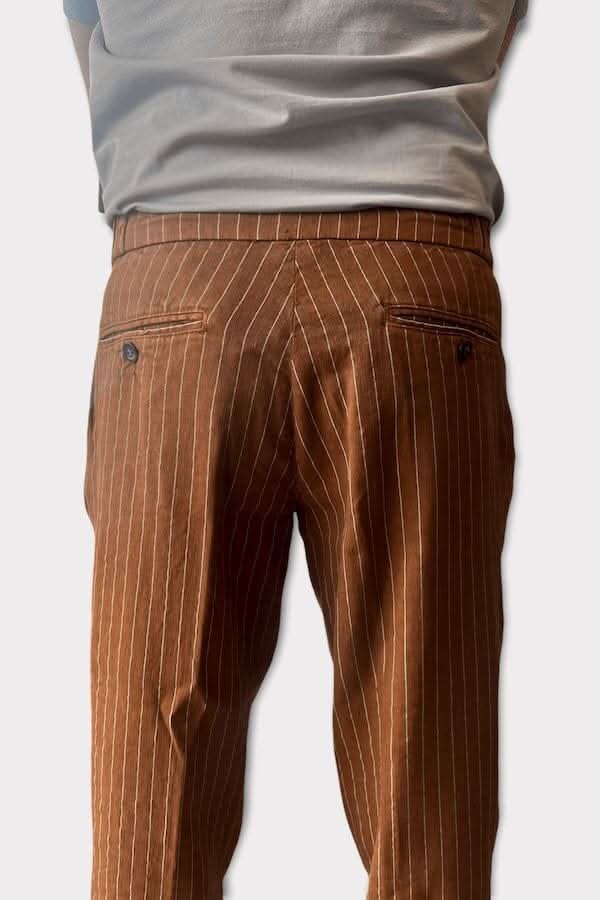 Pantalon ligné en lin marron, vue arrière, avec poches et taille basse, porté avec un t-shirt simple.