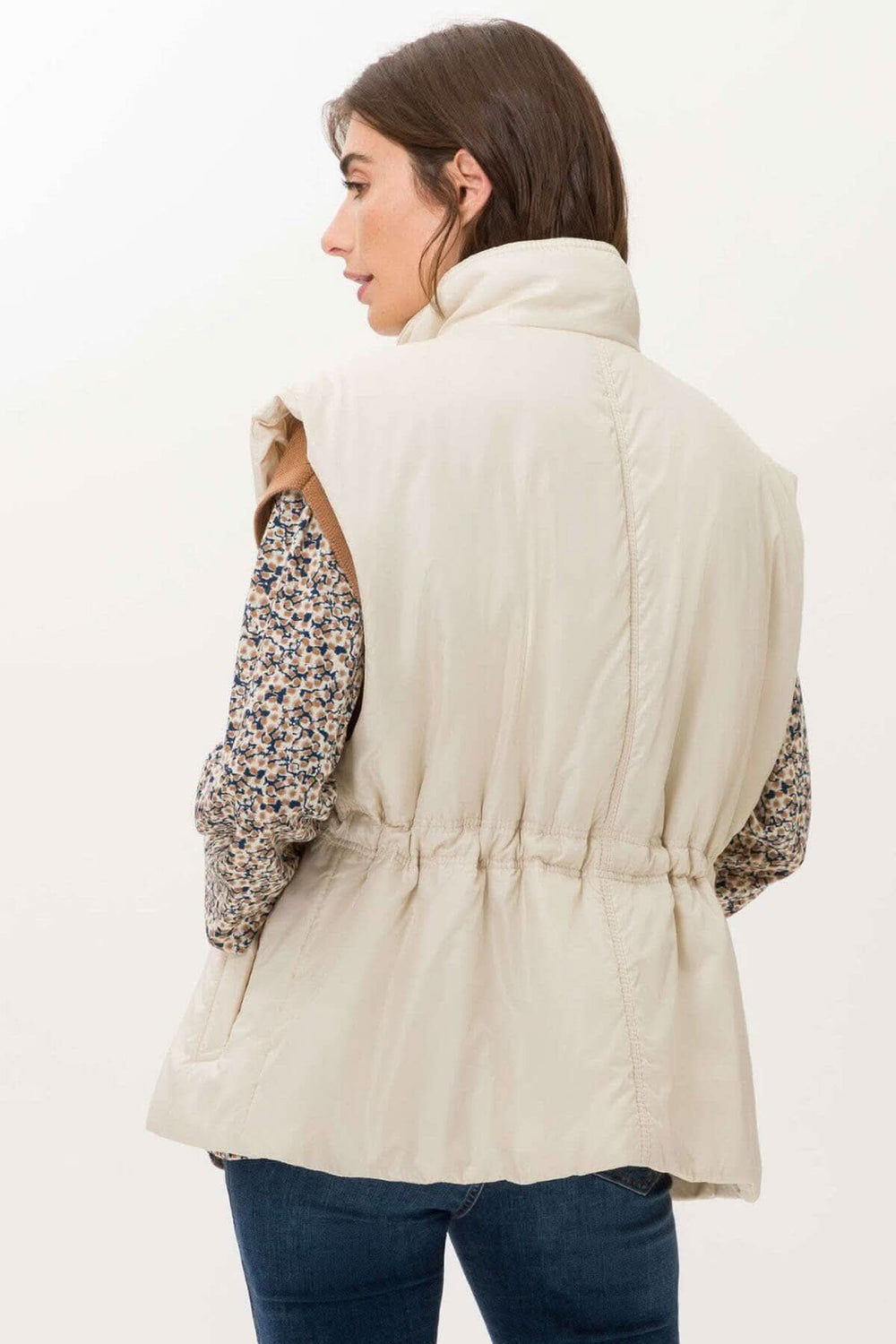 Veste sans manche Monaco beige, avec col haut et taille ajustée, parfaite pour les journées fraîches.