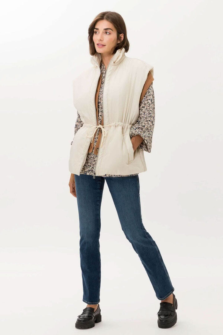 Veste sans manche Monaco, design élégant avec col haut et fermeture éclair à deux sens, portée par modèle.