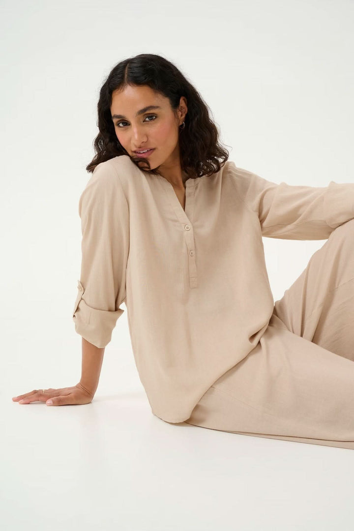 Blouse fluide Milia beige à col tunisien, manches retroussables, style décontracté et élégant.