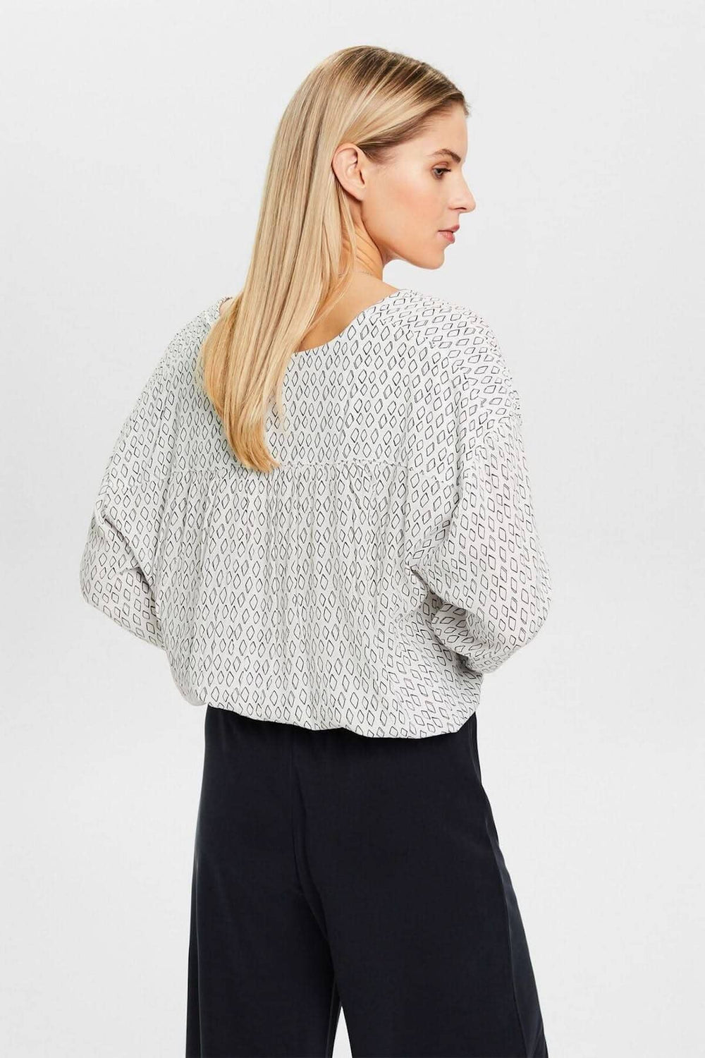 Femme portant un chemisier col V ample au design en crêpe texturé, vue arrière.