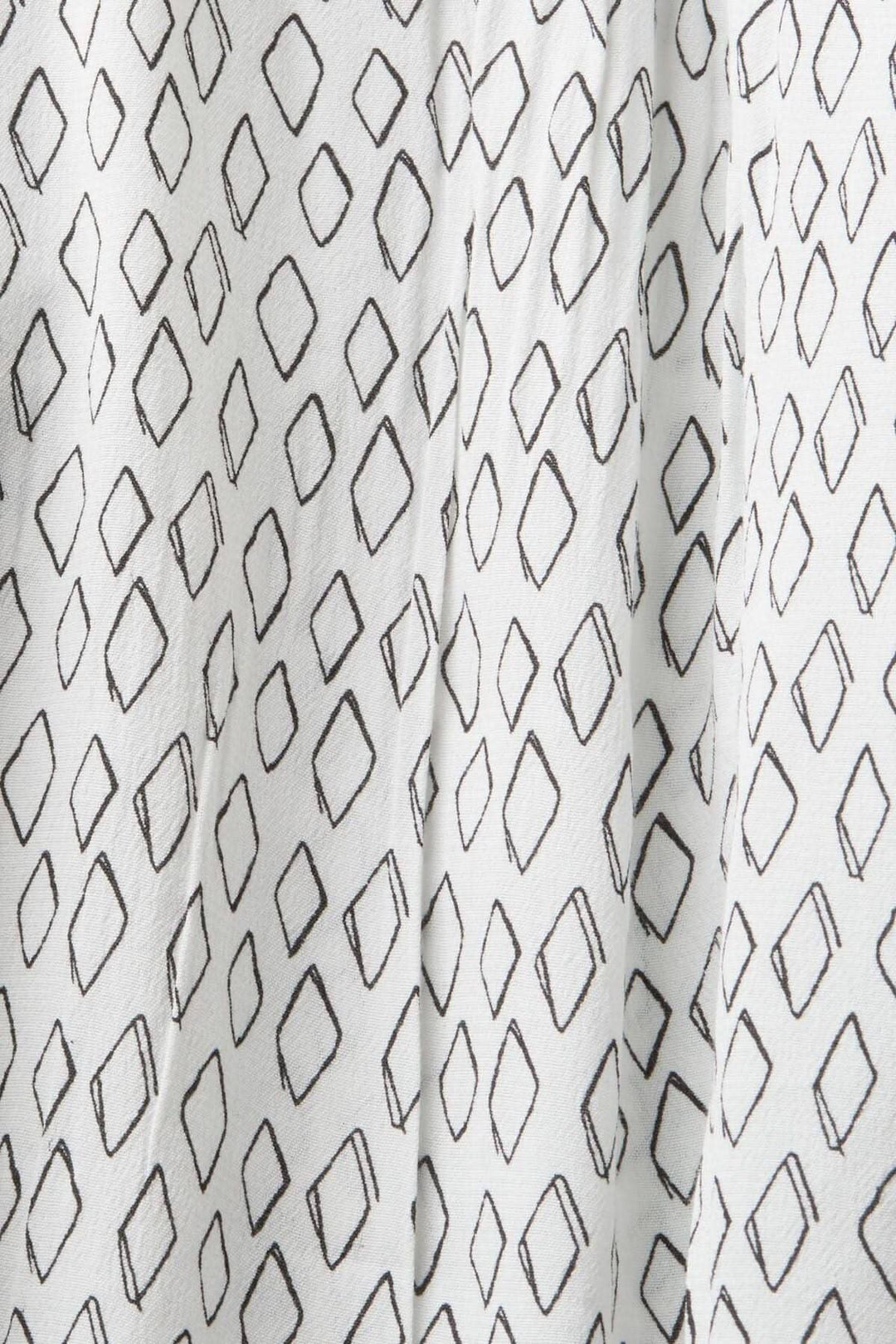Tissu crêpe texturé blanc avec motifs en losanges noirs, idéal pour un chemisier décontracté.