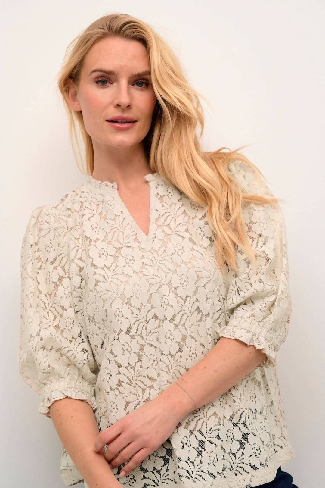 Blouse de Kaspis, élégante en dentelle blanche, manches bouffantes et coupe A, idéale pour le travail ou les sorties.