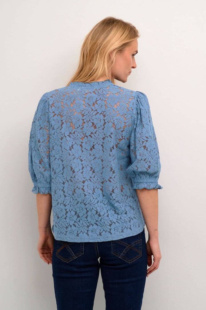 Blouse de Kaspis en dentelle bleue, coupe A, manches mi-longues, vue arrière, idéale pour le travail et les sorties.