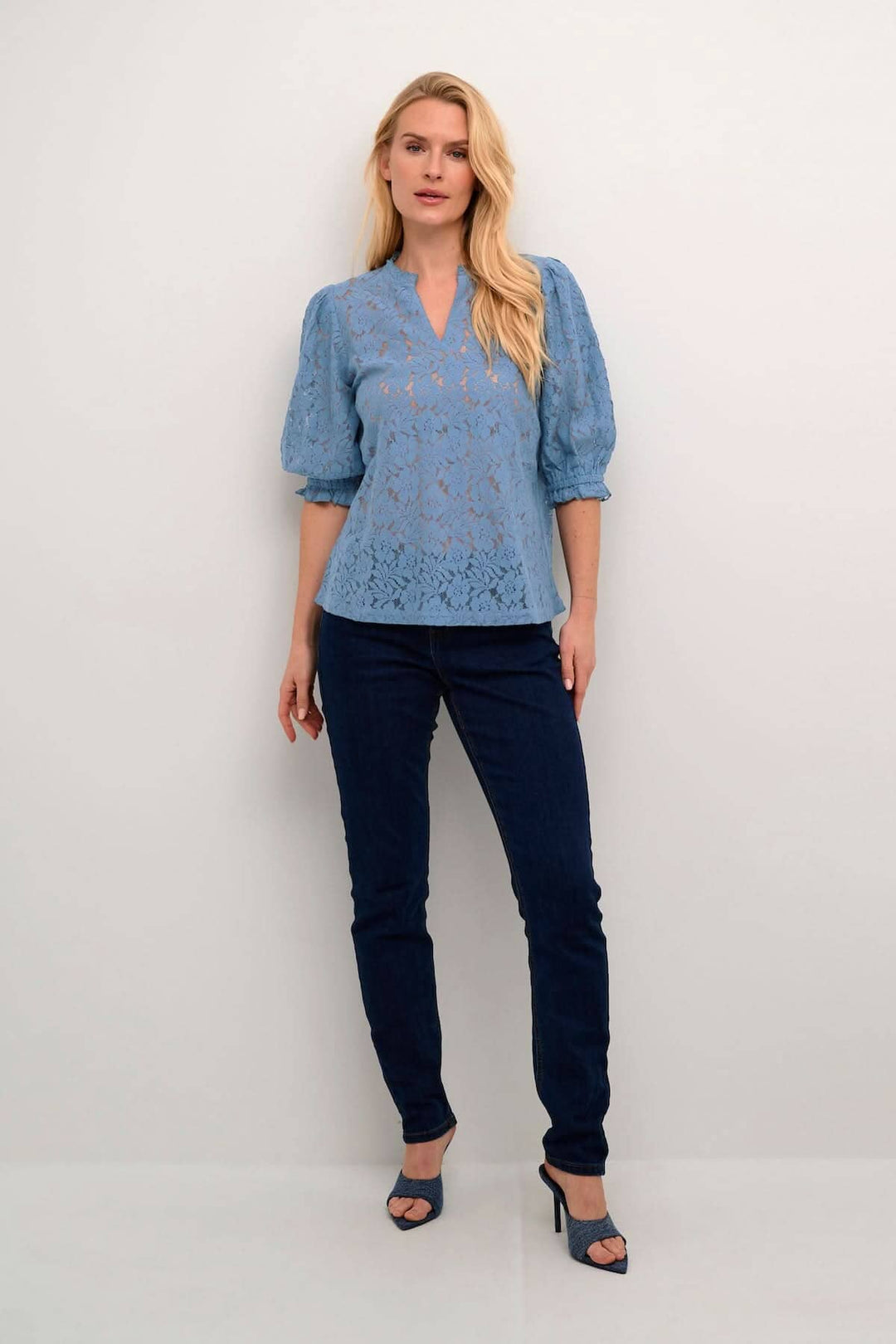 Blouse Kaspis en coton mélange bleu ciel, avec manches bouffantes, portée avec un jean foncé, élégante et décontractée.