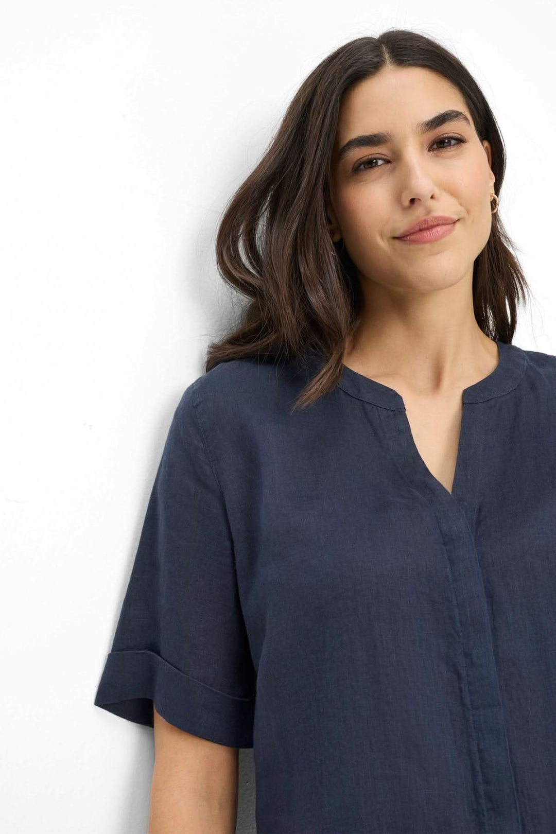 Femme portant la Blouse en lin VERI, manches courtes avec revers, encolure ouverte, bleu marine.