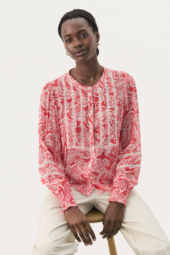 Blouse fluide Nesma à micro-motif fleuri, détails de broderie, manches longues, look féminin et décontracté.