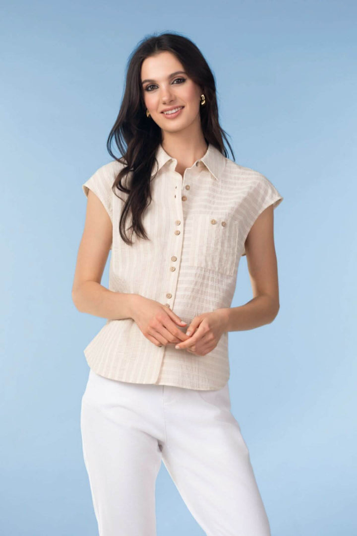 Femme portant une blouse fluide à fines rayures, coupe droite, couleur crème, manches courtes, parfaite pour un style élégant et moderne.