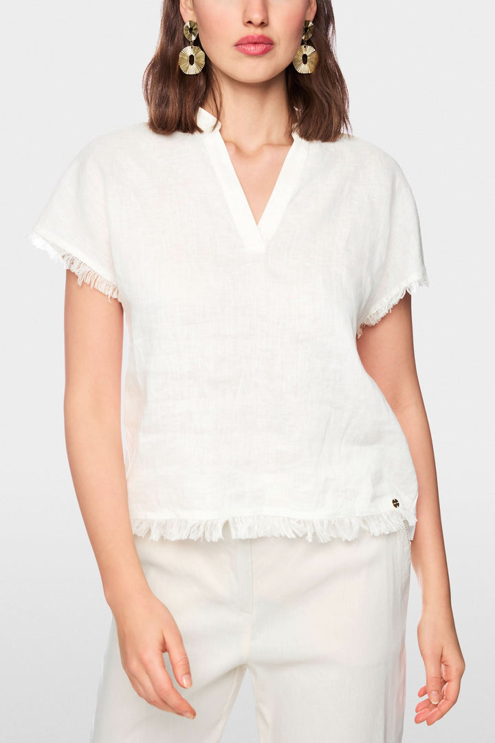 Blouse fluide à finitions effilochées en tissu léger, parfaite pour assortir avec des pantalons habillés ou en denim.