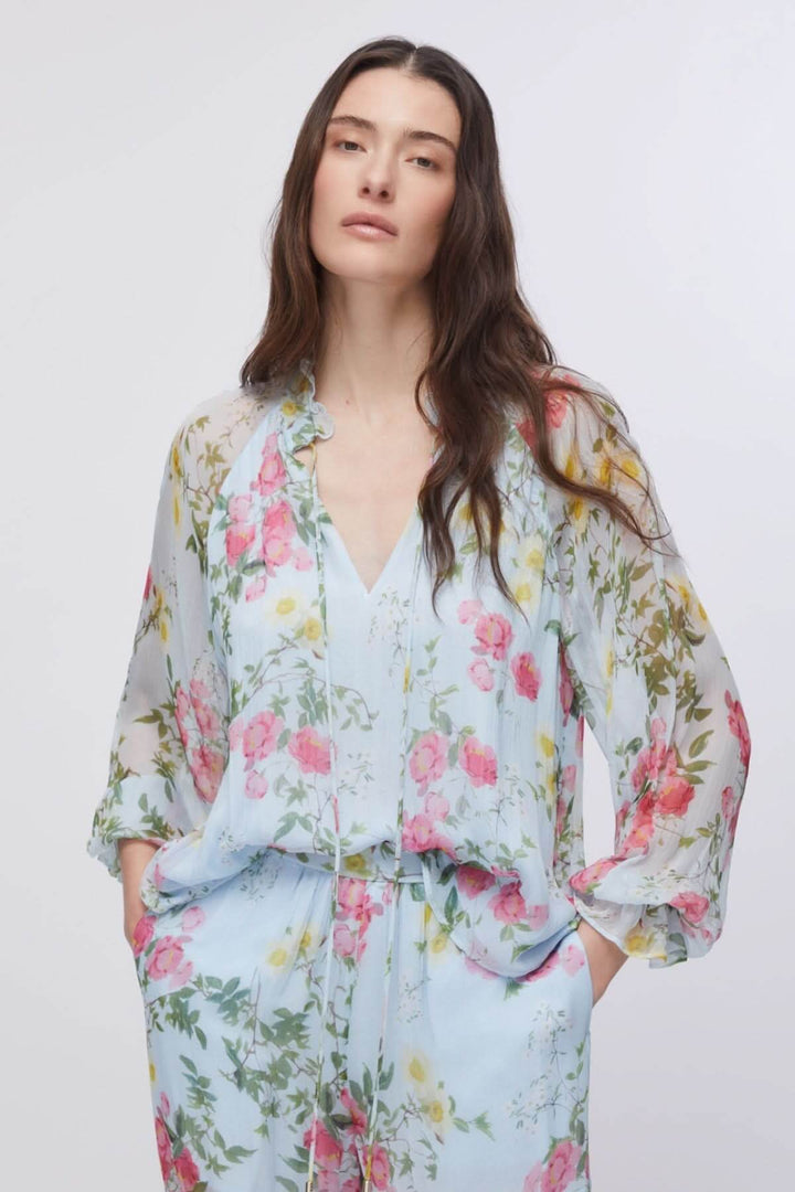 Blouse fluide à imprimé floral avec encolure en V et manches longues bouffantes, ajoutant une touche romantique et raffinée.