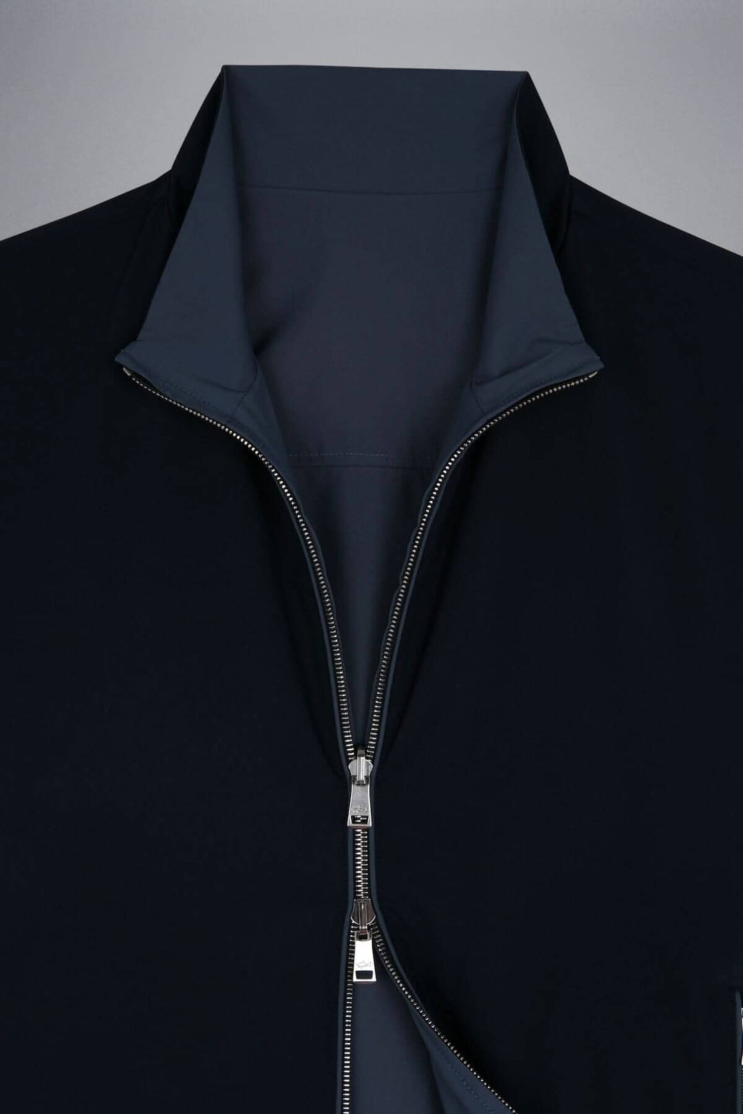 Détails du blouson imperméable réversible avec zip, en tissu noir élégant et moderne.