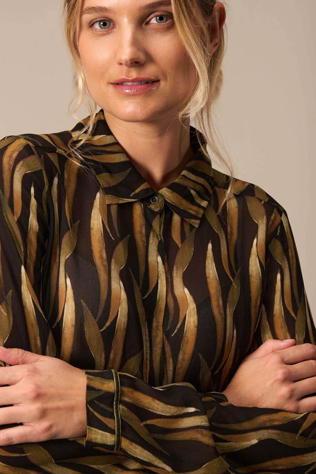 Blouse imprimée végétaux avec motifs audacieux, manches longues et col, portée par un modèle.