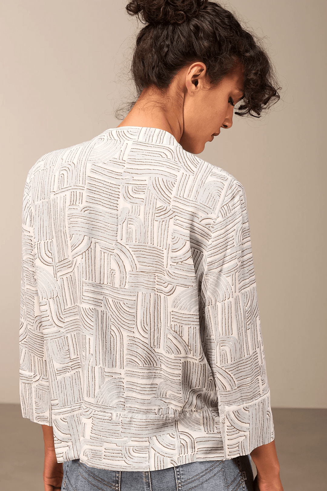 Blouse à manches 3/4 avec motif géométrique, coupe décontractée et col rond, vue de dos. Style moderne et élégant.