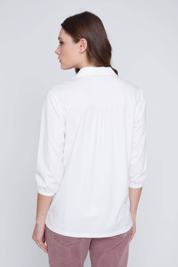 Blouse manches 3/4, femme de dos en blouse blanche avec manches trois-quarts, style élégant et décontracté, tissu fluide.