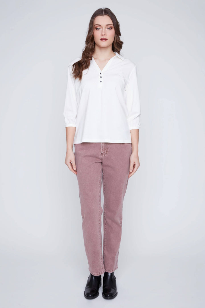 Blouse manches 3/4 avec encolure en V et boutons, portant un style élégant, associée à un pantalon pour un look chic.
