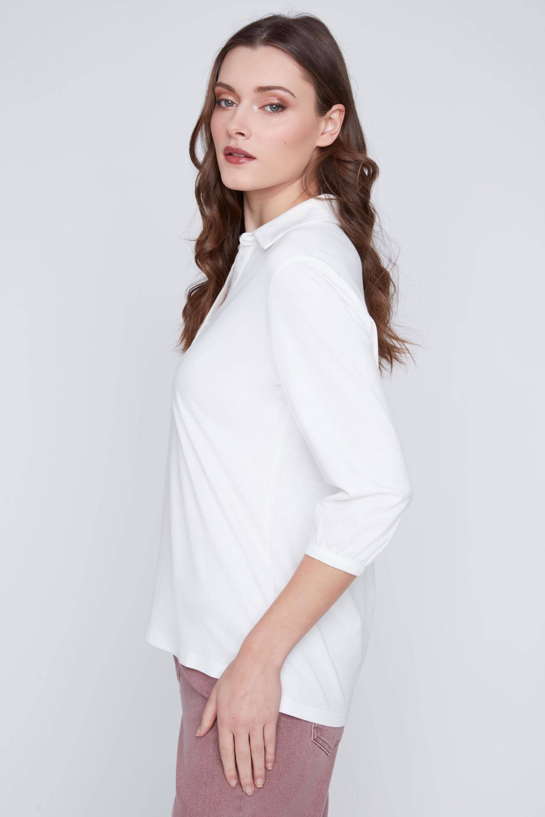 Blouse manches 3/4 blanche avec encolure en V, patte de boutonnage à trois boutons et coupe droite confortable.