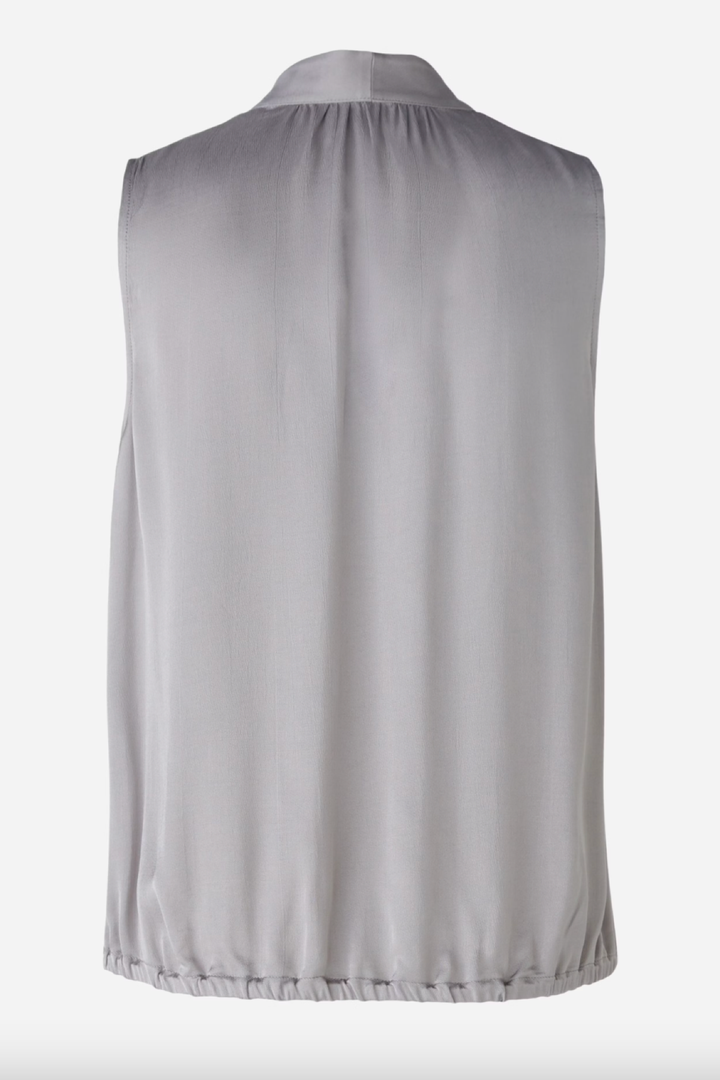 Blouse en satin brillant grise, dos sans manches avec coupe évasée et ceinture élastiquée.