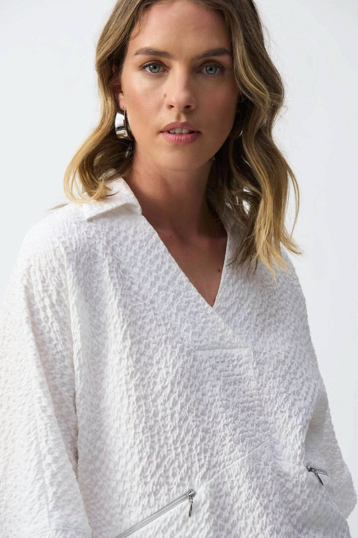 Blouse texturée gaufrée avec encolure en V et poches zippées, portée par un mannequin.