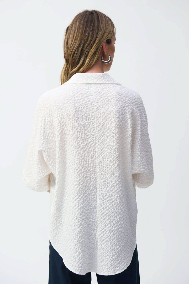 Blouse texturée gaufrée blanche vue de dos, col classique et manches courtes amples, style décontracté.
