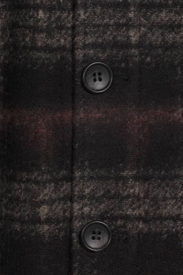Détails du blouson à bouton en mélange de laine et bambou, avec motif à carreaux et boutons noirs.