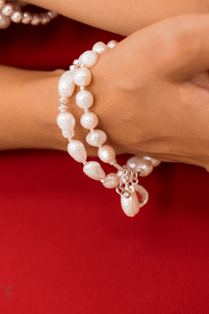 Bracelet en perles d'eau douce avec breloques uniques de la collection Not So Quiet, porté sur un poignet.