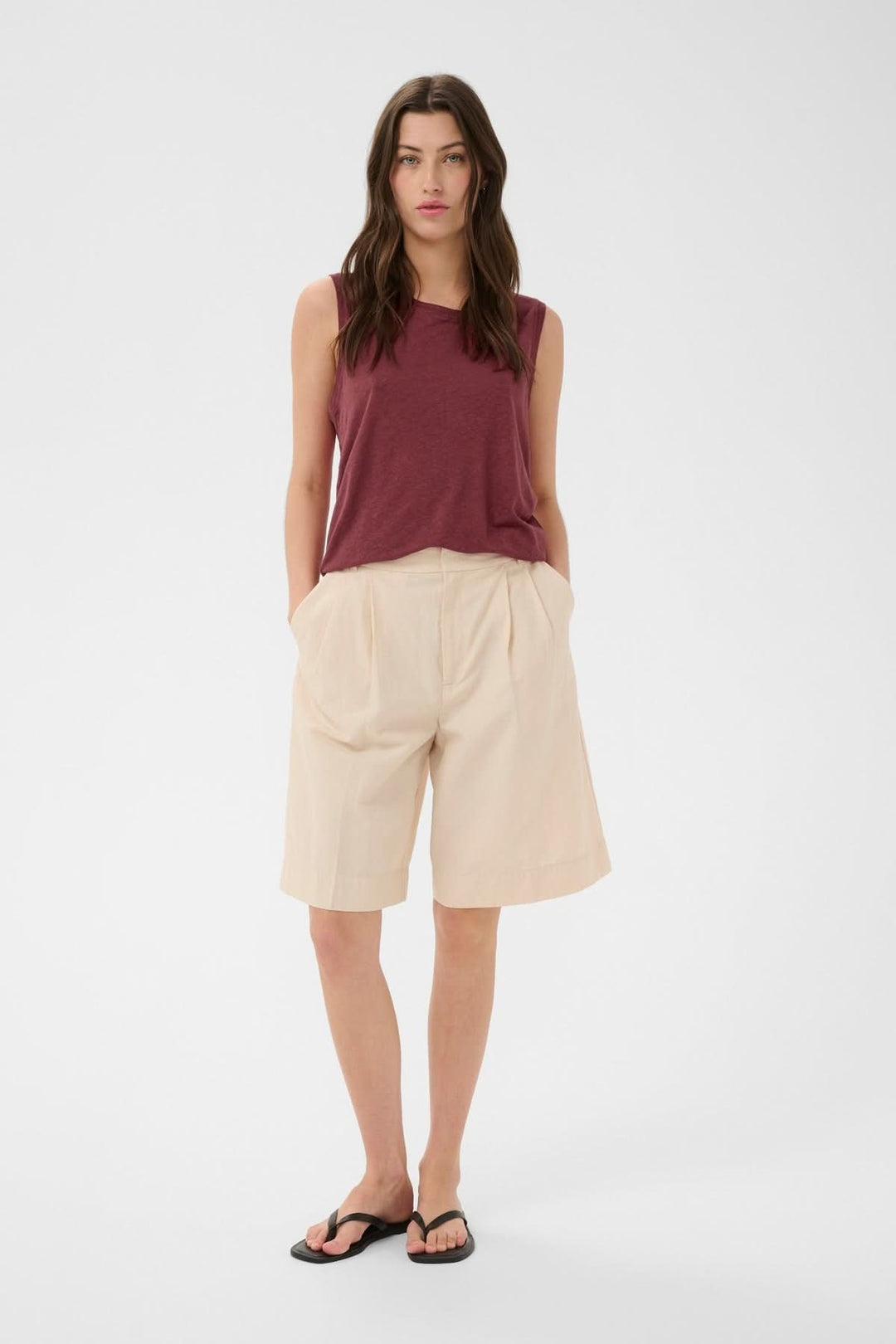 Femme portant la Cami fluide Buena, top sans manches avec encolure ronde, coupe droite et fluide, idéal pour un look polyvalent.