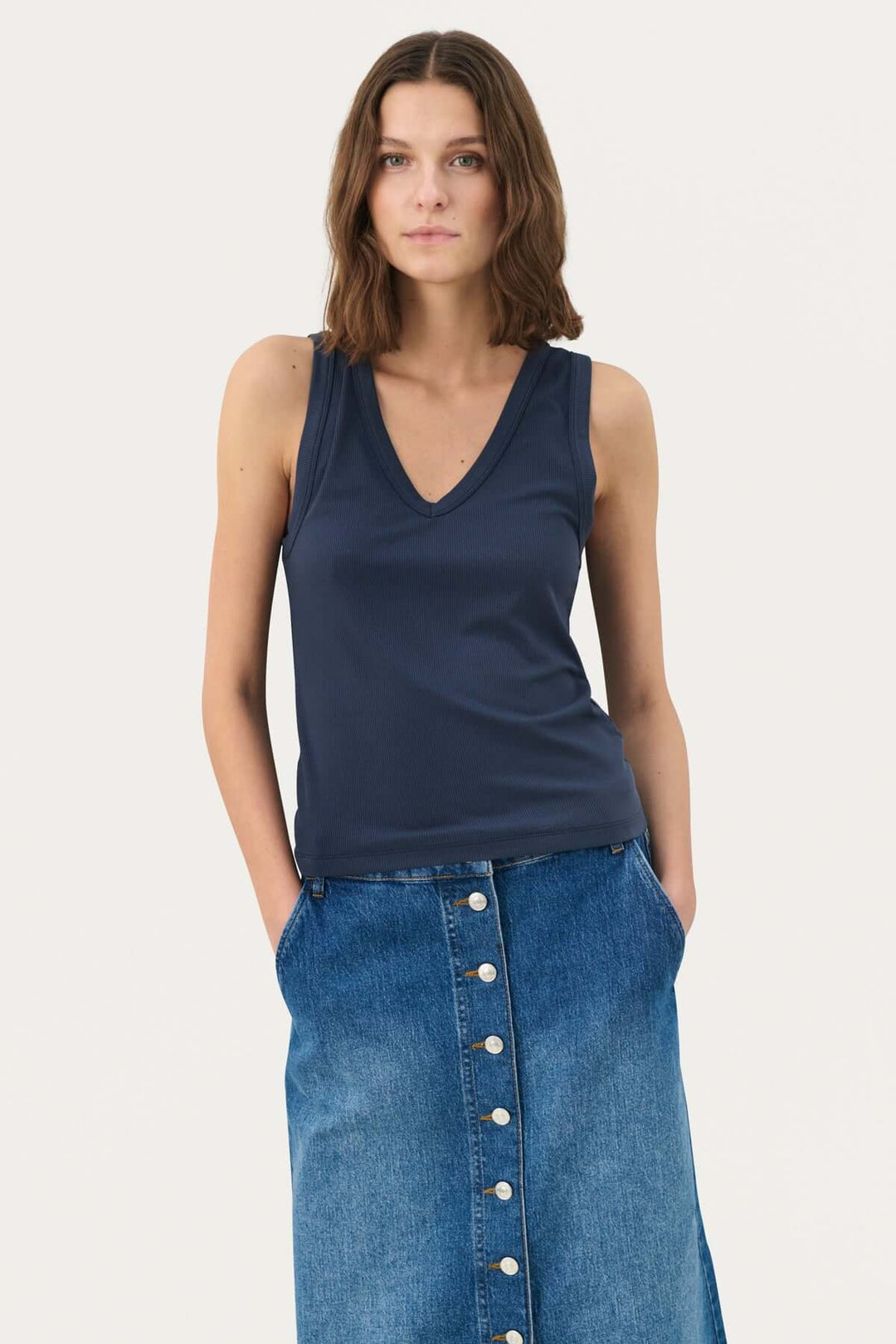 Camisole Nikkia en viscose, col en V, portée avec une jupe en denim, style chic et décontracté.