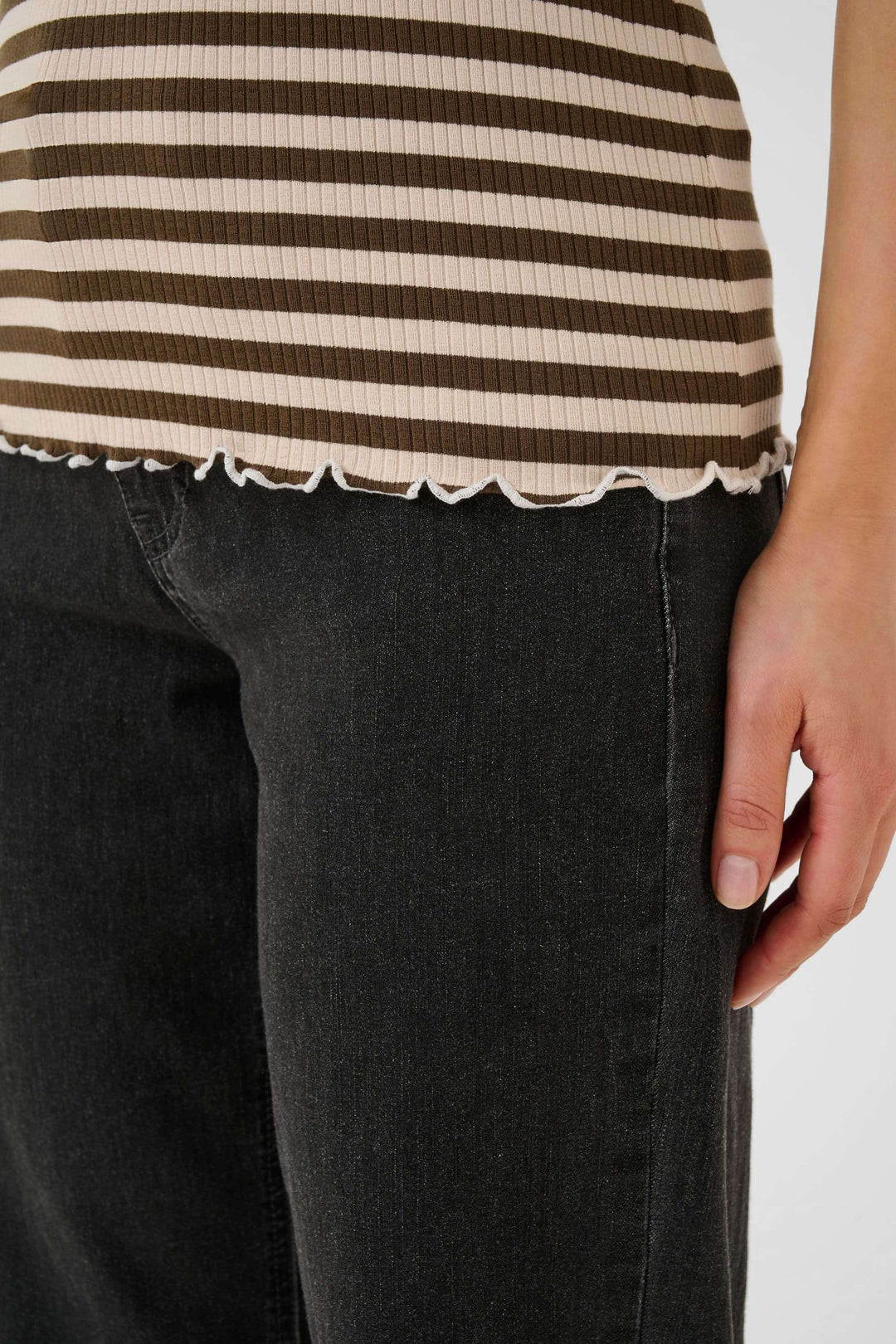 Camisole ribba à rayures horizontales avec finitions ondulées, portée avec un jean noir.