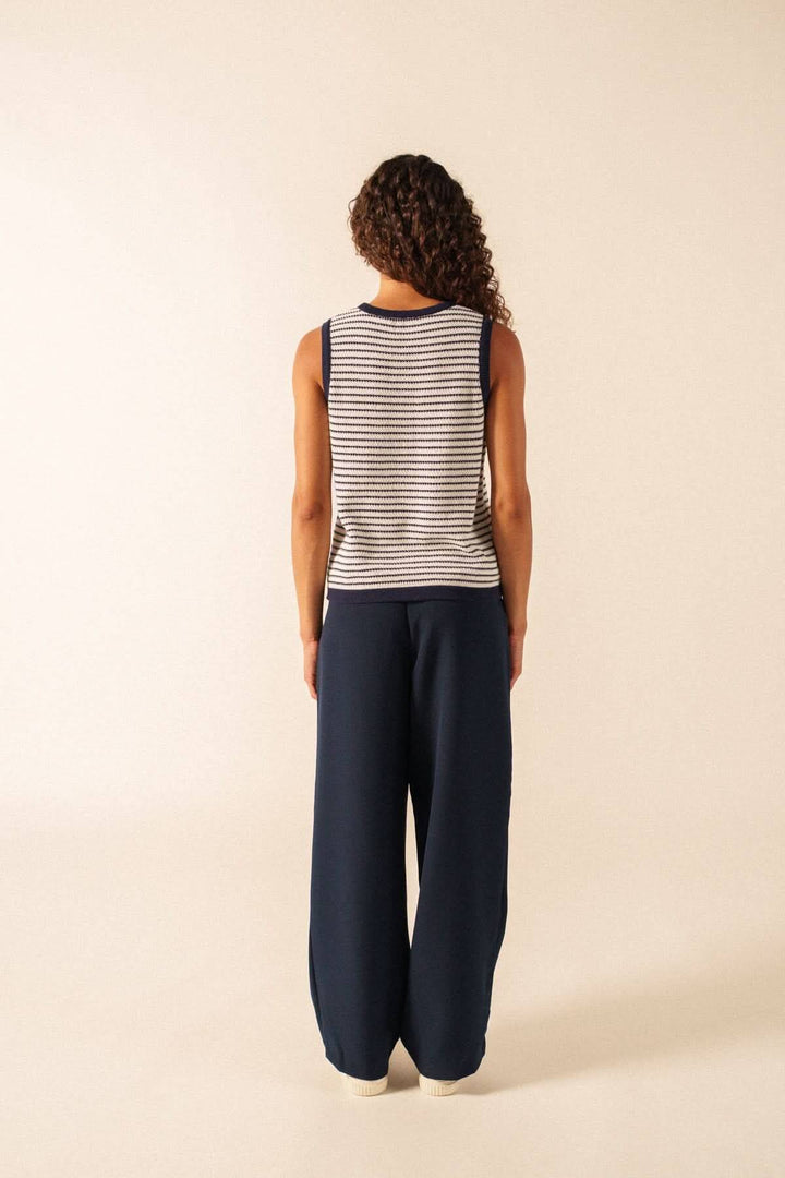 Vue arrière de la Camisole en maille rayée MASSANE, portée avec un pantalon bleu, montrant le motif rayé et la coupe décontractée.