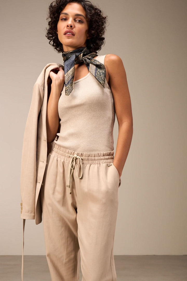 Camisole encolure carrée beige avec pantalon décontracté et foulard, tenue élégante et raffinée.