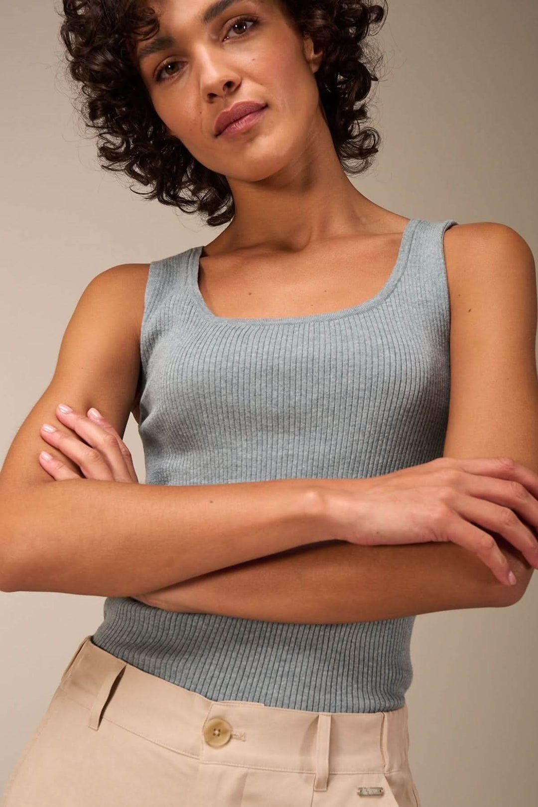 Camisole encolure carrée en tricot côtelé, portée avec un pantalon beige, style moderne et minimaliste.