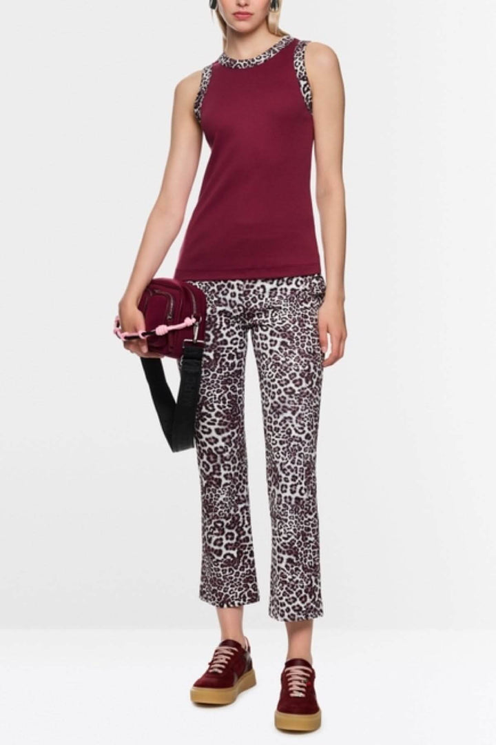 Femme portant une camisole à imprimé léopard près du corps, en coton stretch avec col rond, et tenue assortie élégante.