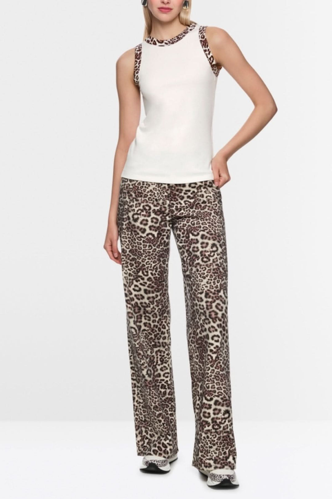 Femme portant une camisole à imprimé léopard en coton côtelé blanc avec bordures léopard, style près du corps.