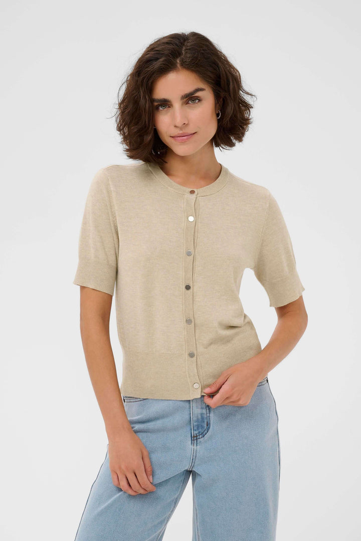 Femme portant le Cardigan Lizza, manches courtes et coupe ajustée, en maille fine, style féminin et épuré pour un look polyvalent.