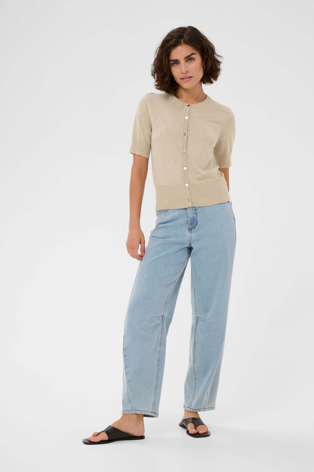 Modèle portant le Cardigan Lizza à manches courtes et coupe ajustée, parfait pour un look décontracté et élégant.