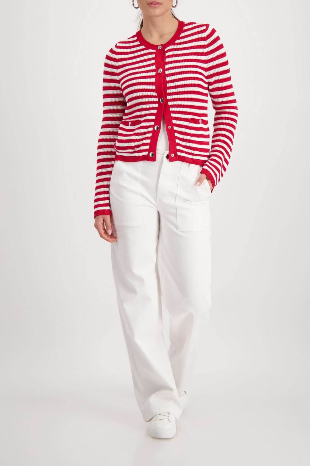 Cardigan rayé boutonné en maille rouge et blanche, coupe droite, porté fermé avec pantalon blanc, allure féminine et structurée.