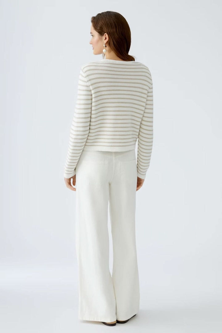 Cardigan à rayures moderne, coupe courte, porté avec un pantalon large, vue arrière, maille texturée élégante.