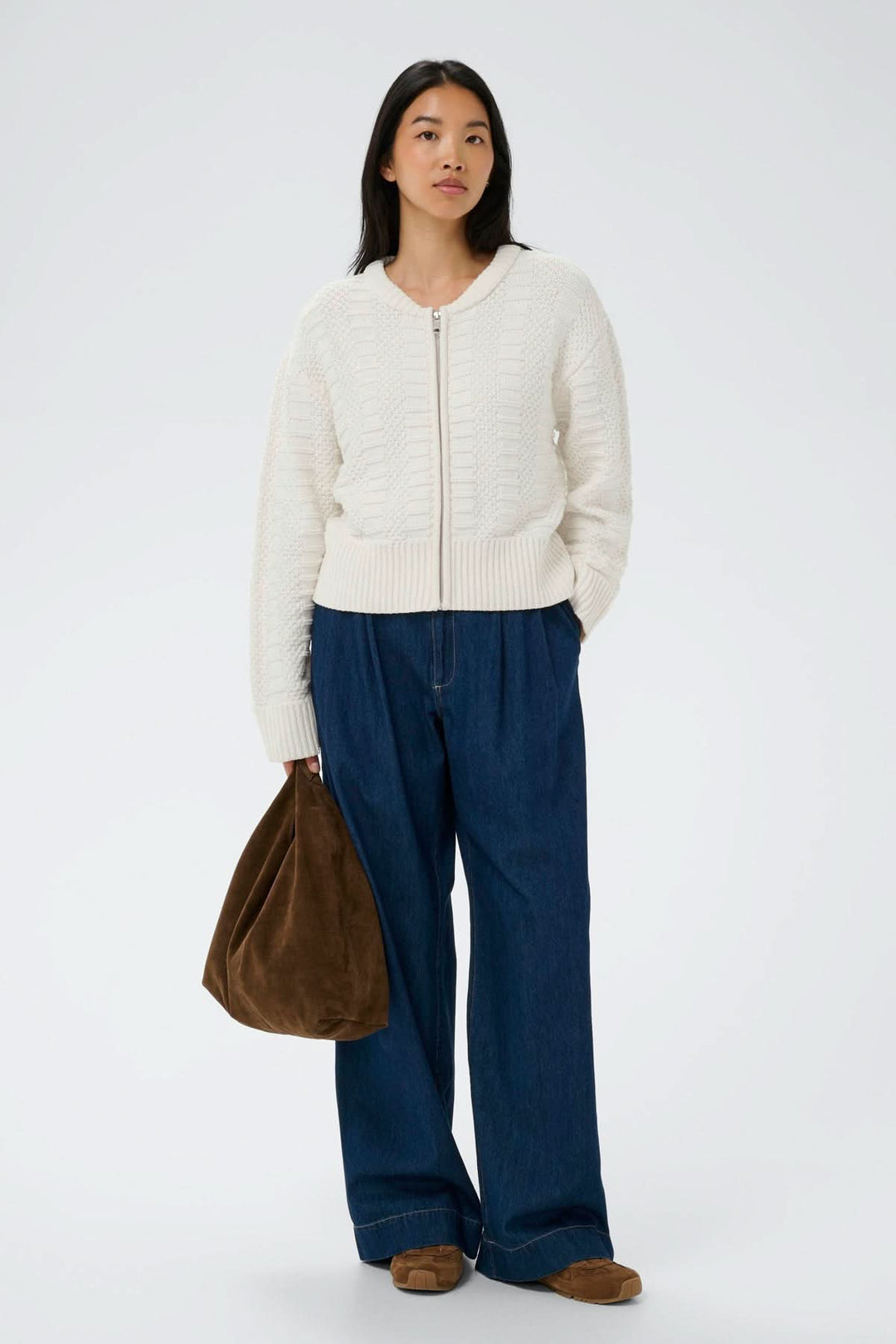 Femme portant le Cardigan zippé Aniela en maille texturée avec une fermeture zippée, style décontracté élégant.