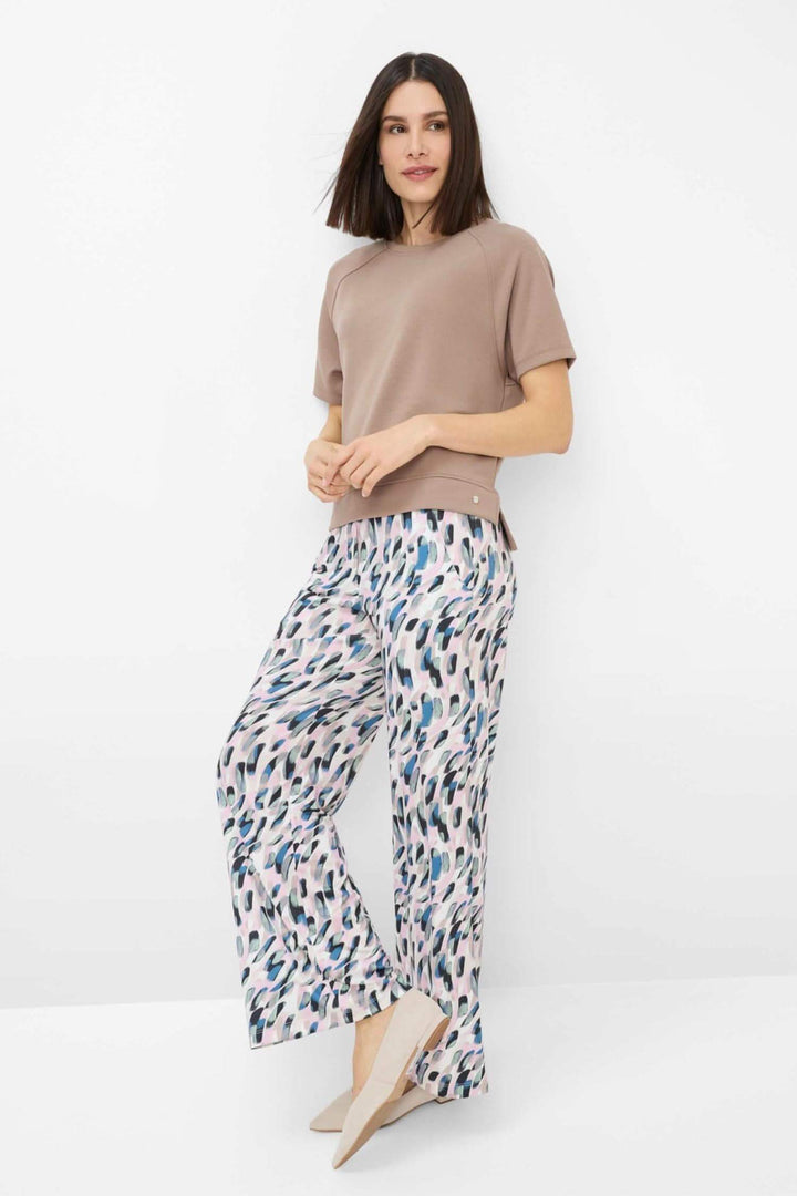 Sweatshirt moderne oversize beige avec pantalon fluide imprimé, look urbain et contemporain.
