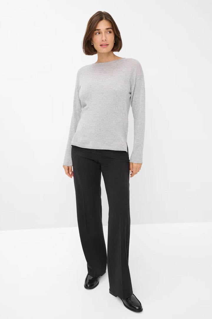 Chandail Liz en maille fine, col bateau, porté avec un pantalon noir, style chic et décontracté.