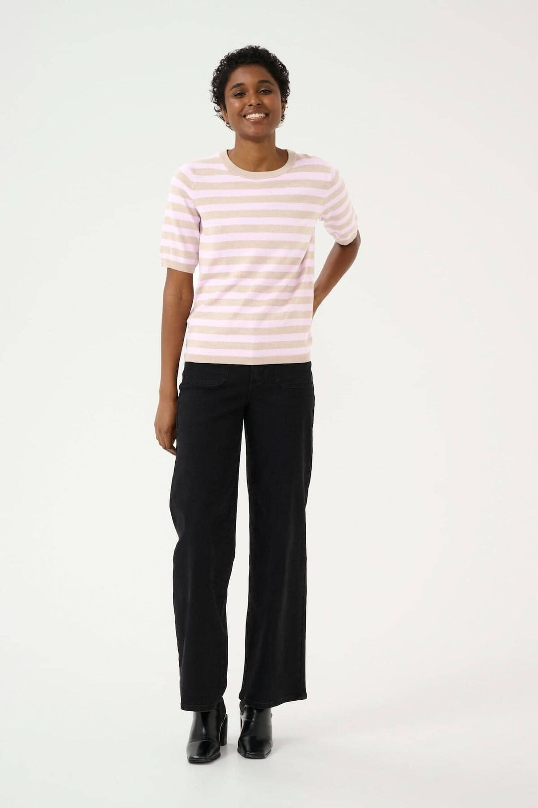 Chandail Lizza à manches courtes avec motif ligné, porté avec un pantalon noir pour un look décontracté et stylé.