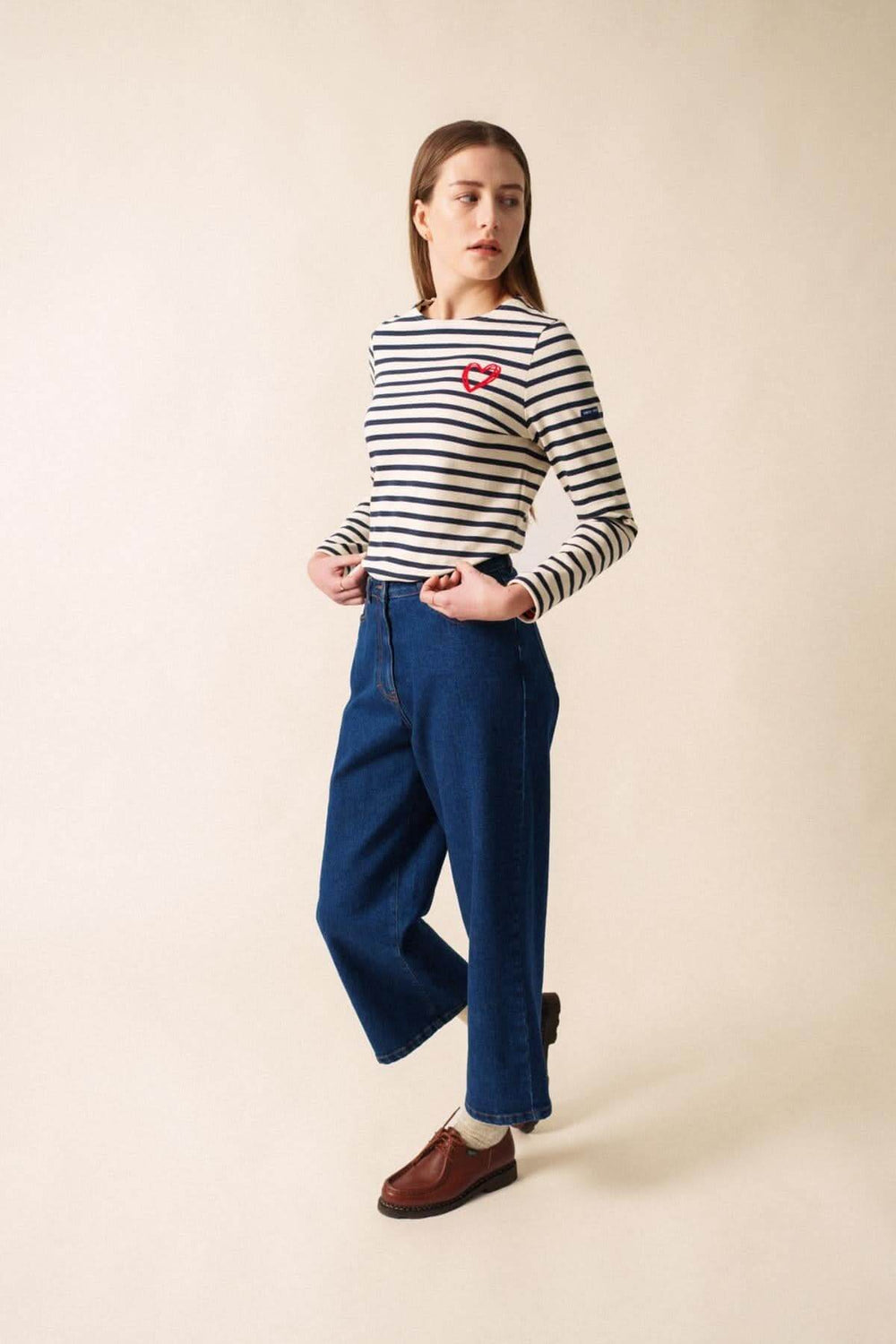 Chandail MERID'AMOUR marinière rayée avec motif cœur en velours, porté avec pantalon bleu, style casual-chic.