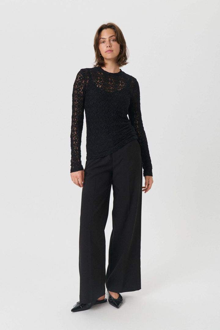 Femme portant Chandail Venetia transparent en dentelle, élégant et féminin, parfait pour un look chic. Manche longue, texture délicate.