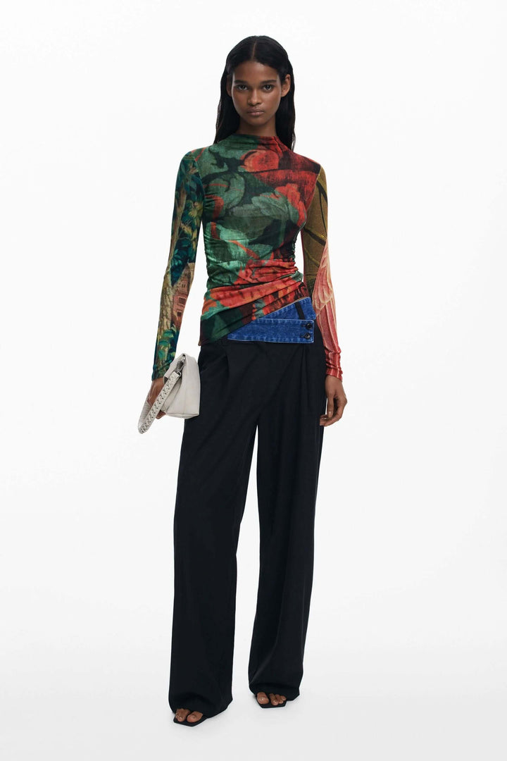 Chandail ajusté à imprimé floral automnal, design seconde peau et fronces latérales, porté avec un pantalon noir élégant.