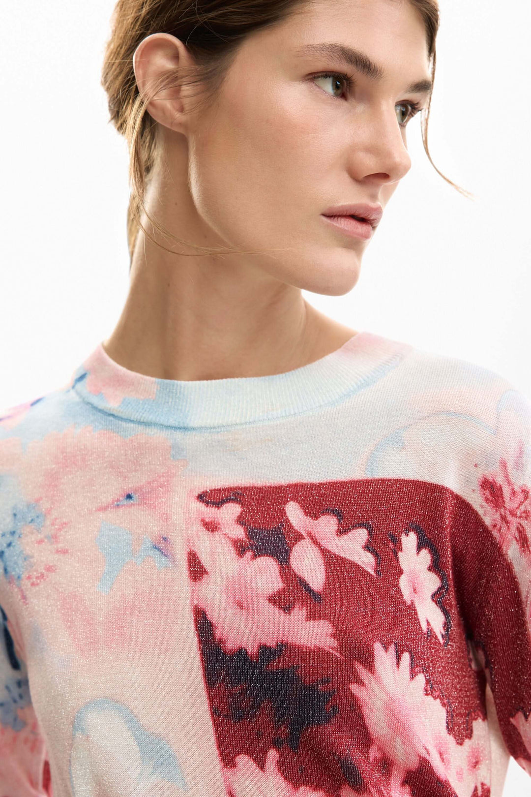 Femme portant un chandail avec collage artistique aux motifs floraux et coupe ajustée.