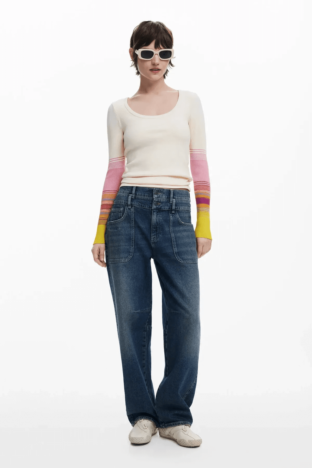Femme portant un chandail à col rond à manches dégradées et un jean ample, style décontracté avec lunettes de soleil.