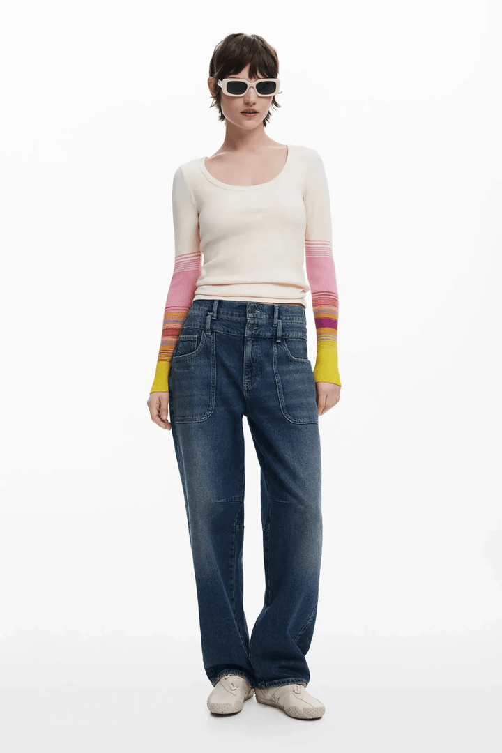 Femme portant un chandail à col rond à manches dégradées et un jean ample, style décontracté avec lunettes de soleil.