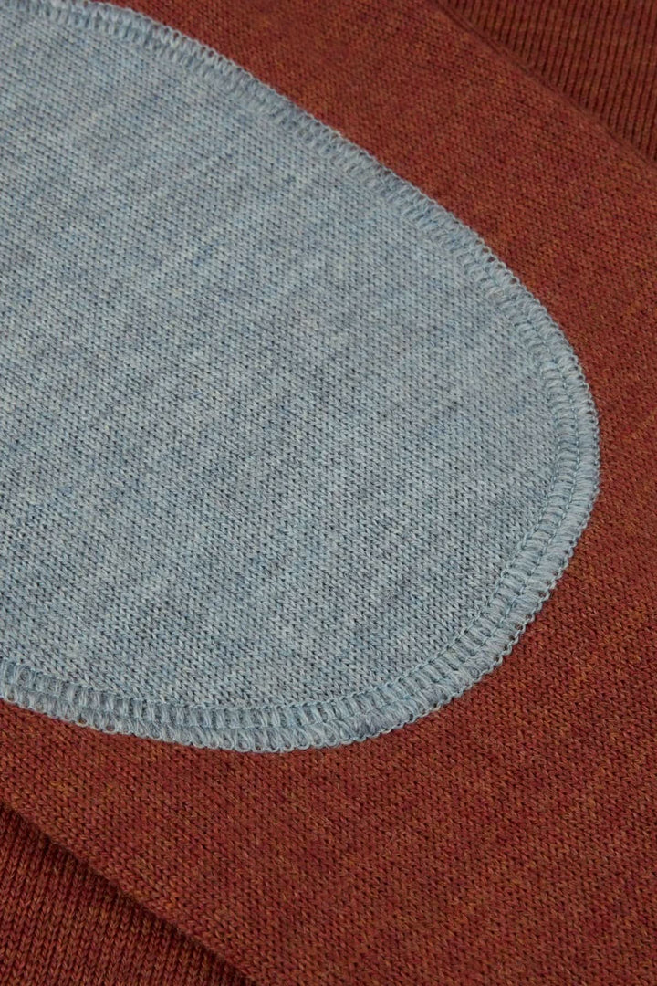 Détail coudière contrastante sur chandail col rond en laine mérinos. Chandail col rond en laine mérinos avec coudes contrastants.
