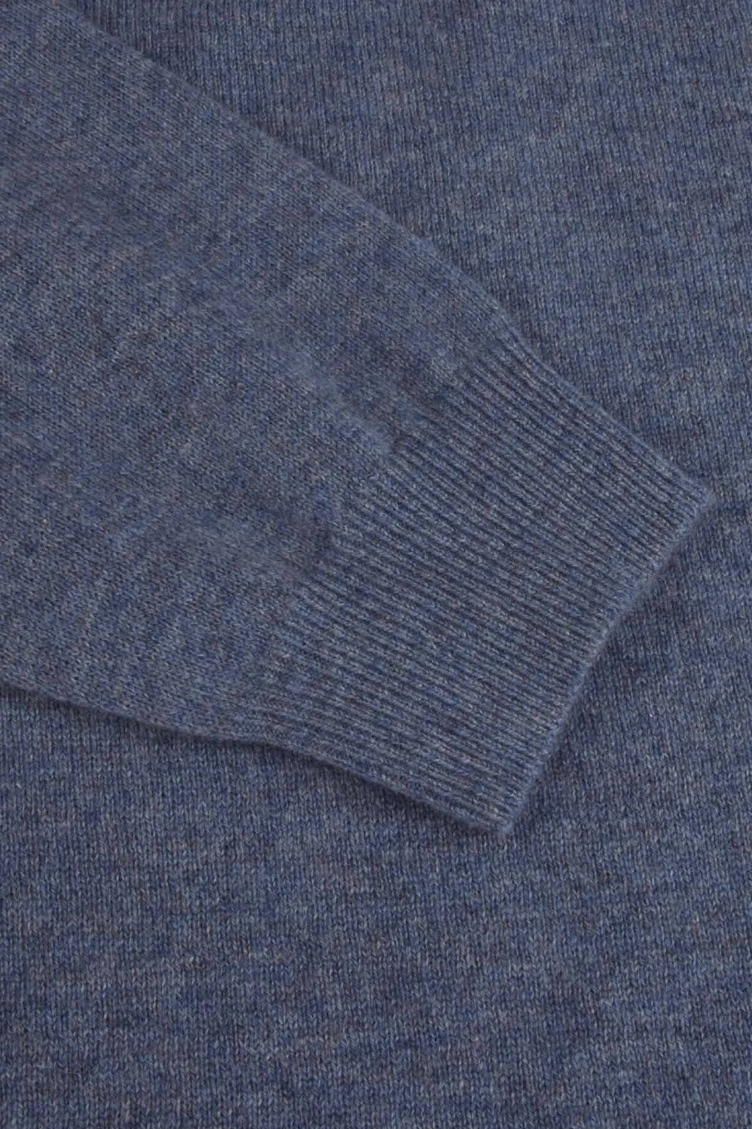 Détail du chandail de cachemire Stenströms en bleu, montrant une manche avec bordures côtelées.