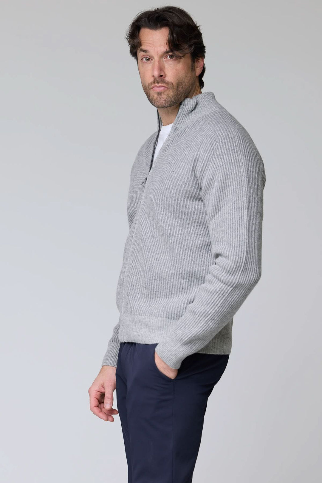 Homme portant un chandail à demi-glissière torsadé en laine mérinos gris avec manche longue et col montant, style élégant et polyvalent.